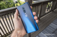 A hand holding a OnePlus 7 Pro so that you can see the back, which is the Nebula Blue color.