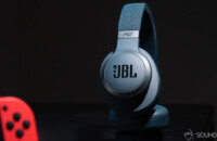 JBL Live 650BTNC Google Assistant headphones with noise cancelling on black surface with part of Nintendo Switch in the foreground.