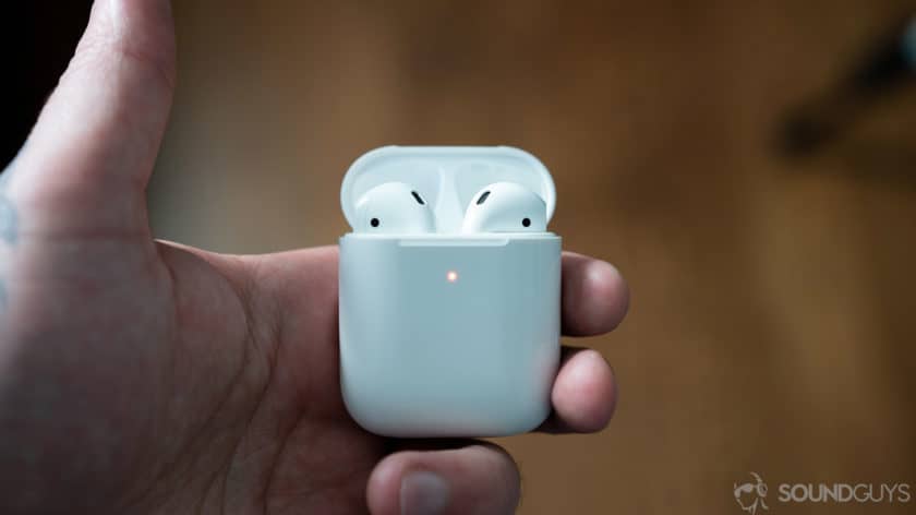 airpods 2 in charging case A picture of the AirPods 2 in wireless charging case held by man's hand.