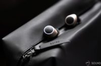 An image of the Creative Outlier Air earbuds in champagne gold on a black waterproof bag.