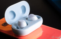 A picture of the Samsung Galaxy Buds in case on top of a Samsung Galaxy S10e smartphone in Flamingo Pink.